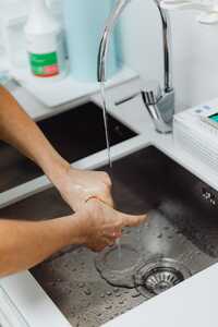 Closeup of hands being washed at sink